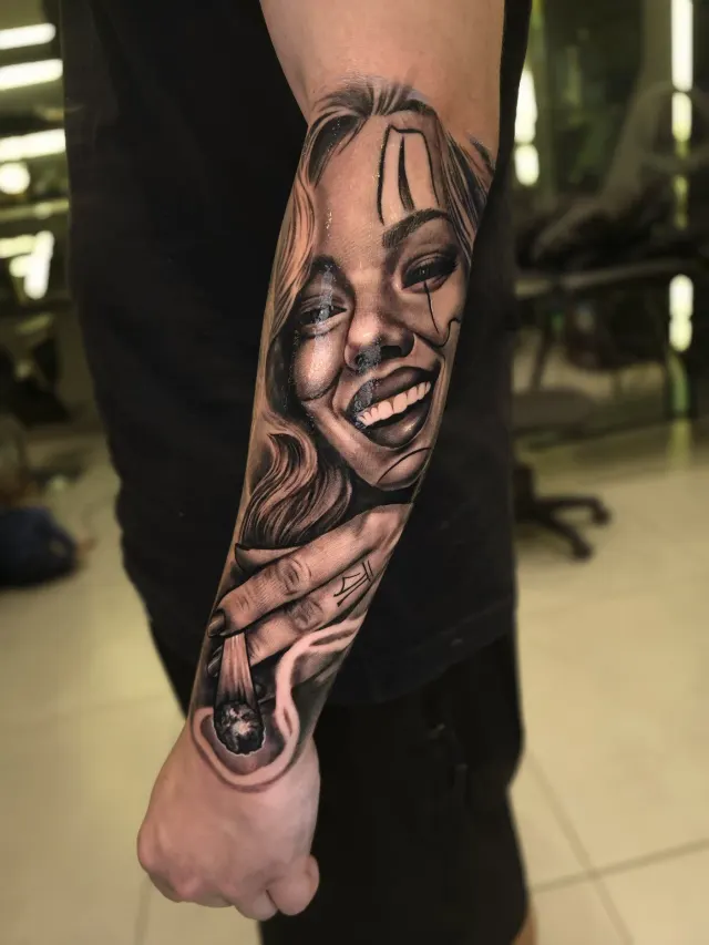 Tatuagem de rosto feminino estilo chicano em realismo no antebraço